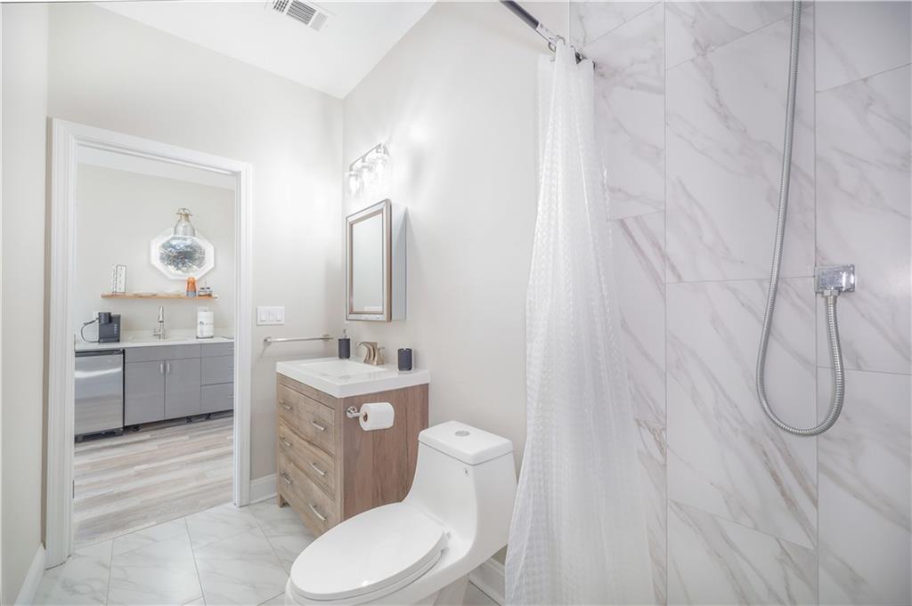 5997 Warpath Road Flowery Branch, GA 30542 - Photo 51 of 76 a bathroom with a toilet sink and mirror