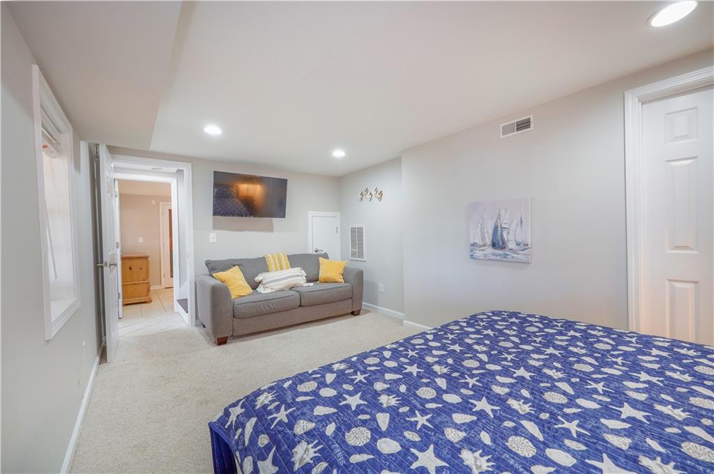 5997 Warpath Road Flowery Branch, GA 30542 - Photo 60 of 76 a bedroom with a bed and a couch