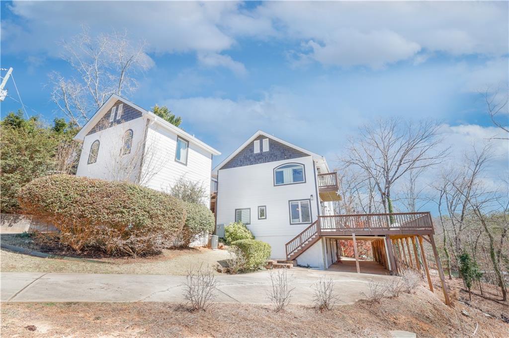 5997 Warpath Road Flowery Branch, GA 30542 - Photo 10 of 76 a view of a white house with a large tree and wooden fence