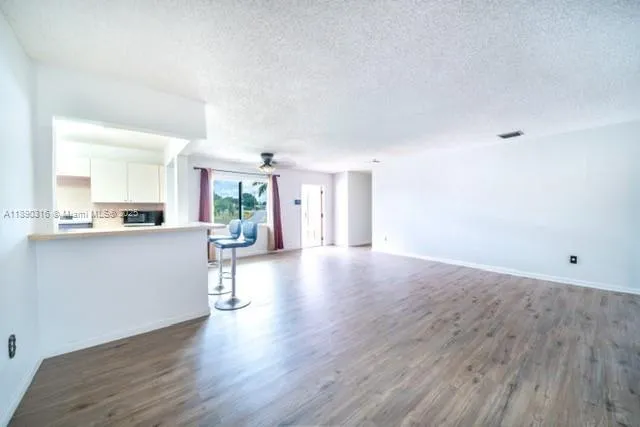 a view of a kitchen with furniture and wooden floor