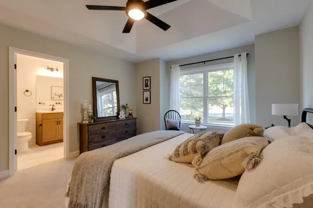 a bedroom with a large bed and a chandelier