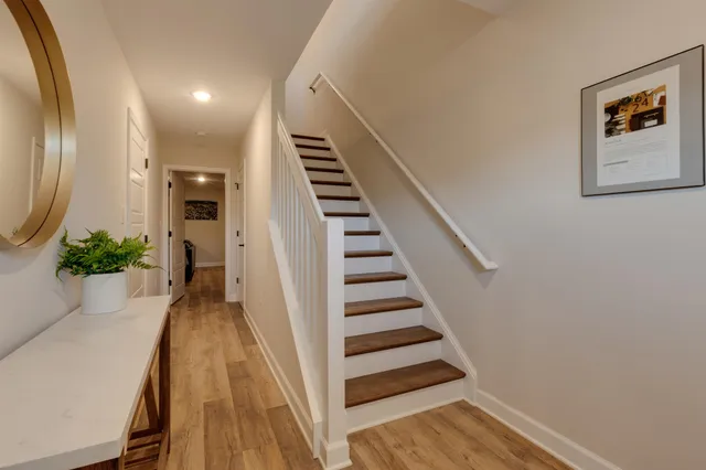 a view of a hallway with wooden floor and stairs