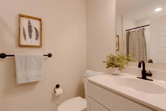 a bathroom with a sink toilet and a mirror