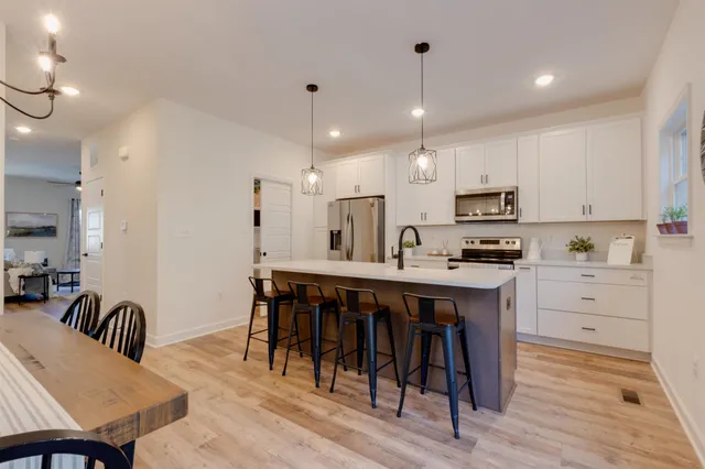 a kitchen with kitchen island granite countertop a sink a center island and appliances