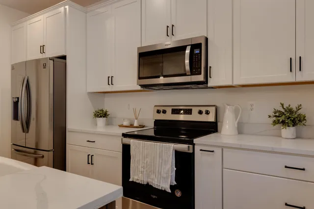 a kitchen with stainless steel appliances a stove microwave and refrigerator