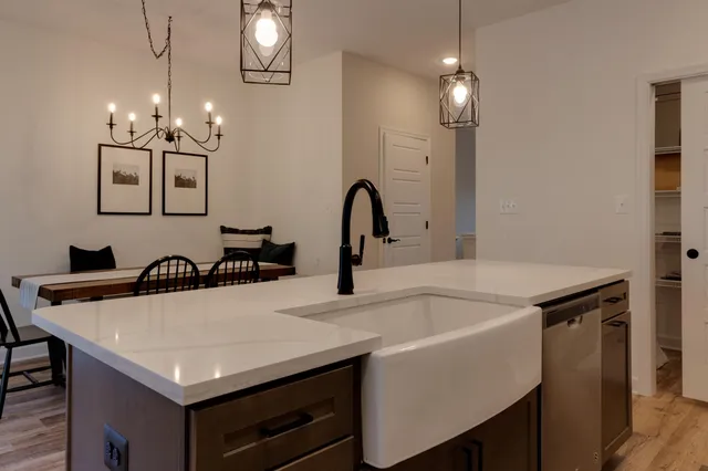 a kitchen with a table chairs and a chandelier