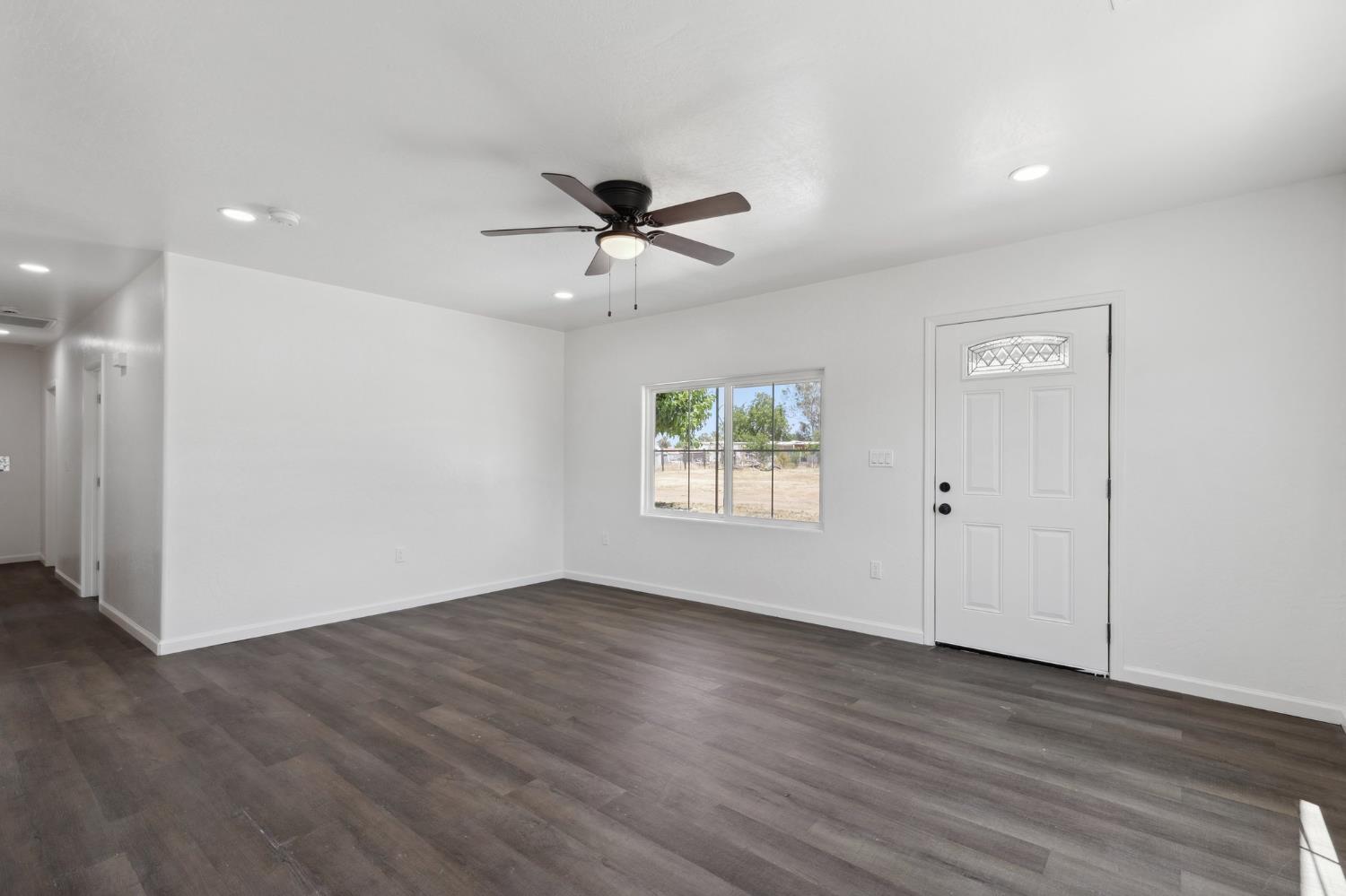 27747 Echo Road Madera, CA 93638 - Photo 11 of 38 a view of an empty room with a window and wooden floor