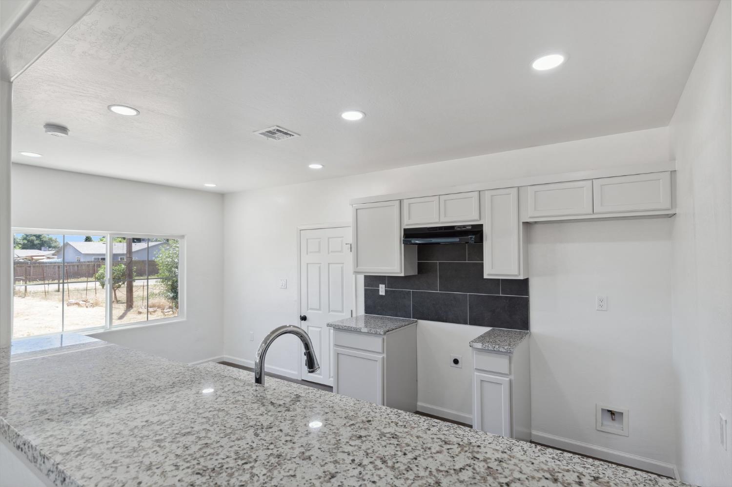 27747 Echo Road Madera, CA 93638 - Photo 17 of 38 a kitchen with stainless steel appliances kitchen island granite countertop a refrigerator and a sink