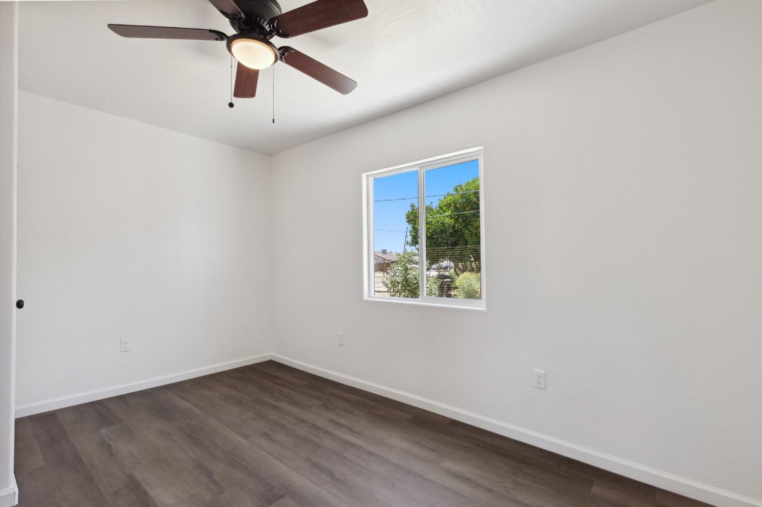 27747 Echo Road Madera, CA 93638 - Photo 18 of 38 an empty room with a window and a ceiling fan