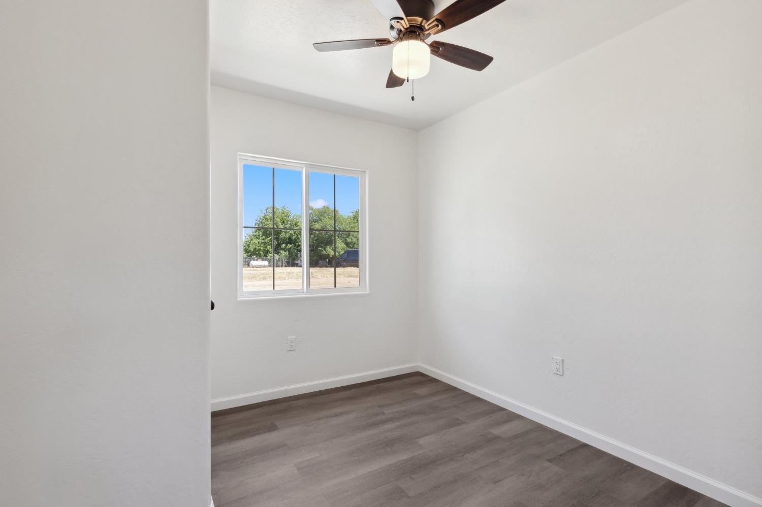 27747 Echo Road Madera, CA 93638 - Photo 20 of 38 an empty room with a window and a fan