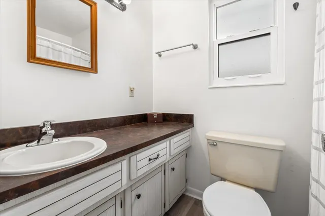 a bathroom with a granite countertop toilet sink and mirror