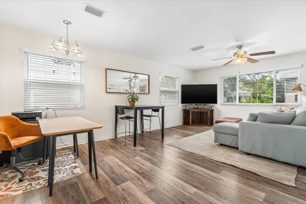 a living room with furniture a flat screen tv and kitchen view
