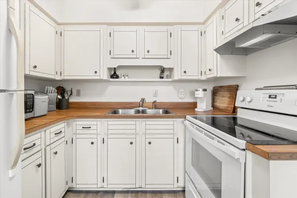 a kitchen with white cabinets and white appliances