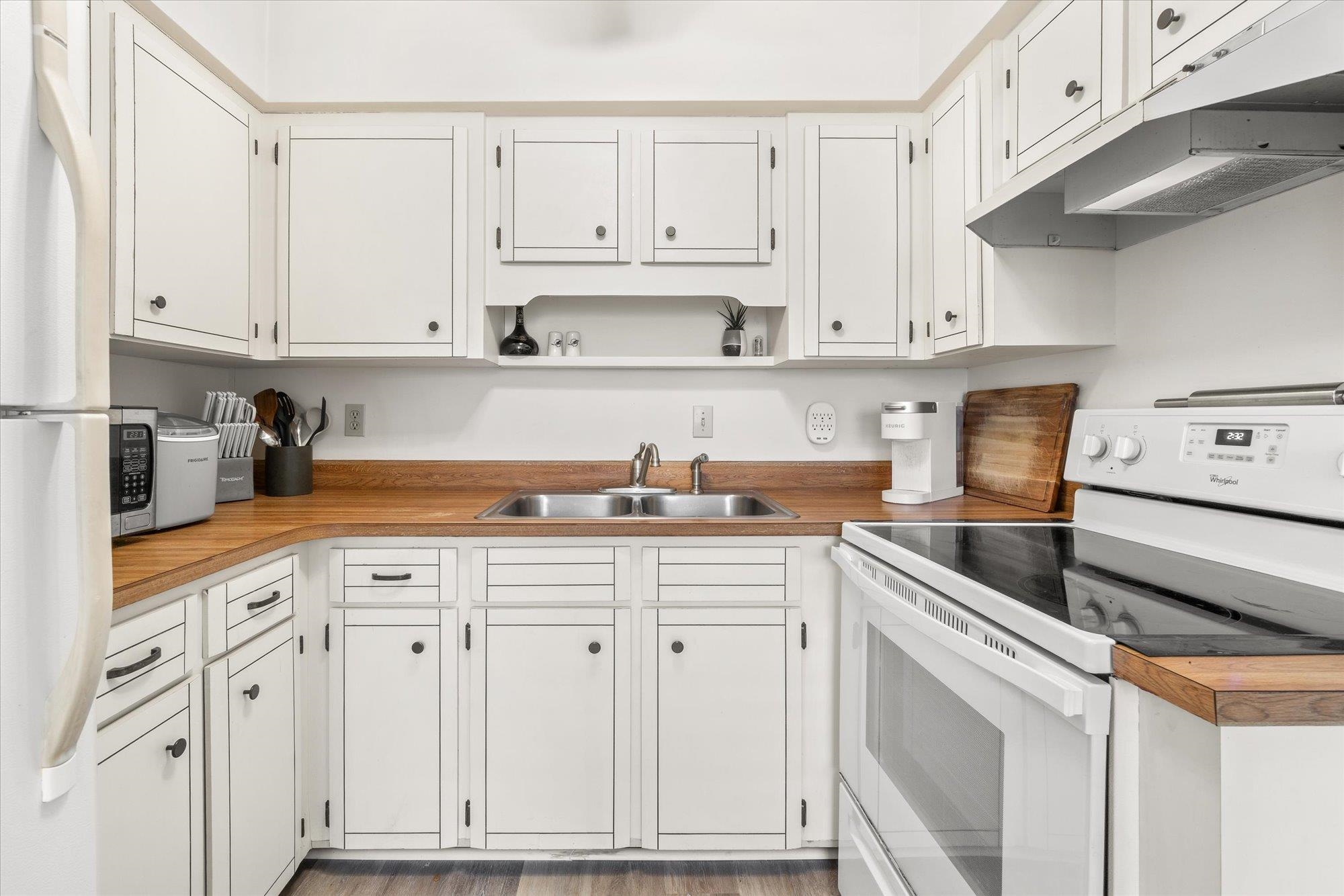 216 9th Street St. Augustine, FL 32080 - Photo 8 of 35 a kitchen with white cabinets and white appliances