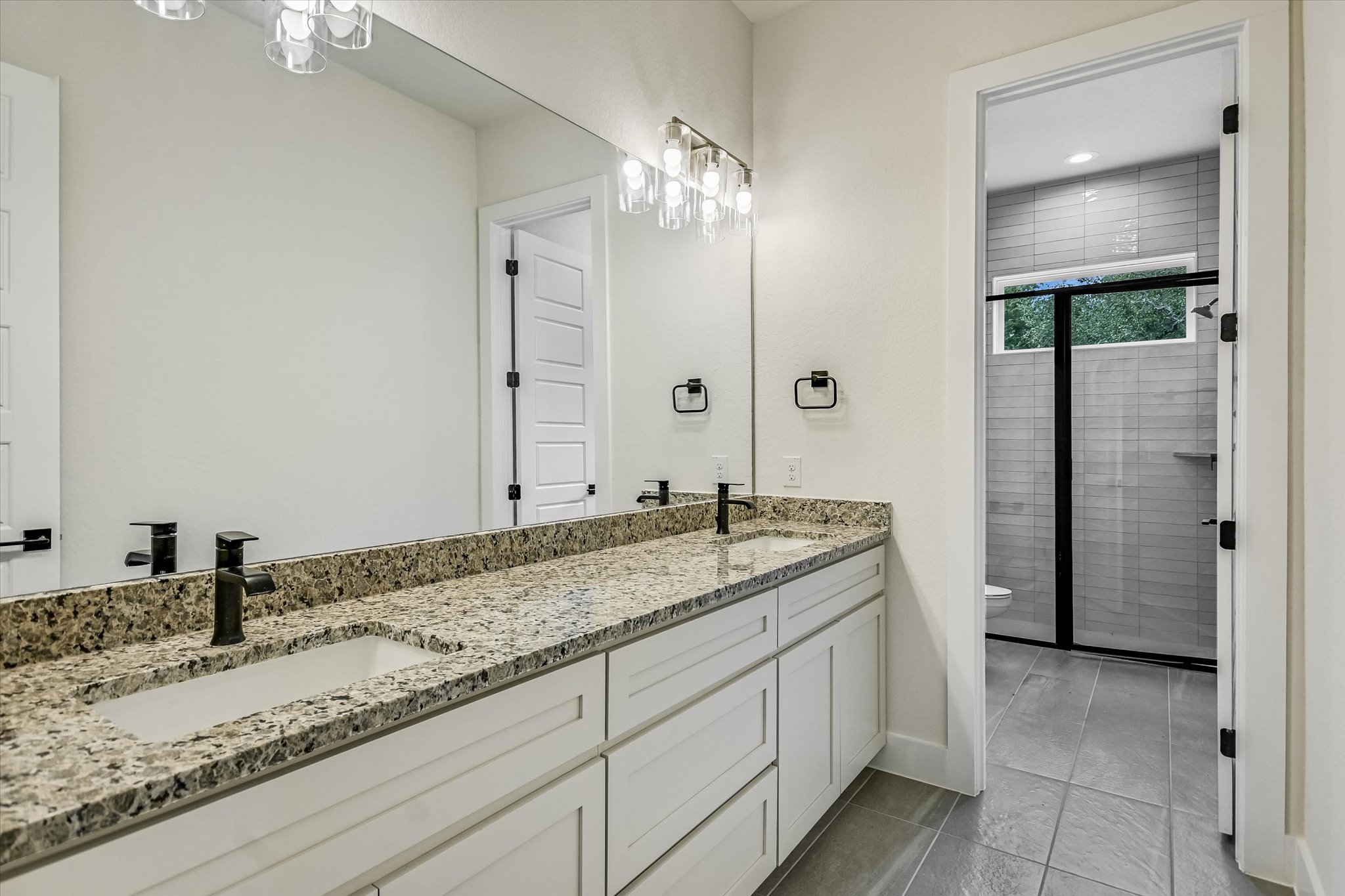 32 Peace Pipe Wimberley, TX 78676 - Photo 17 of 20 Bathroom with a stall shower, double vanity, and light tile patterned flooring