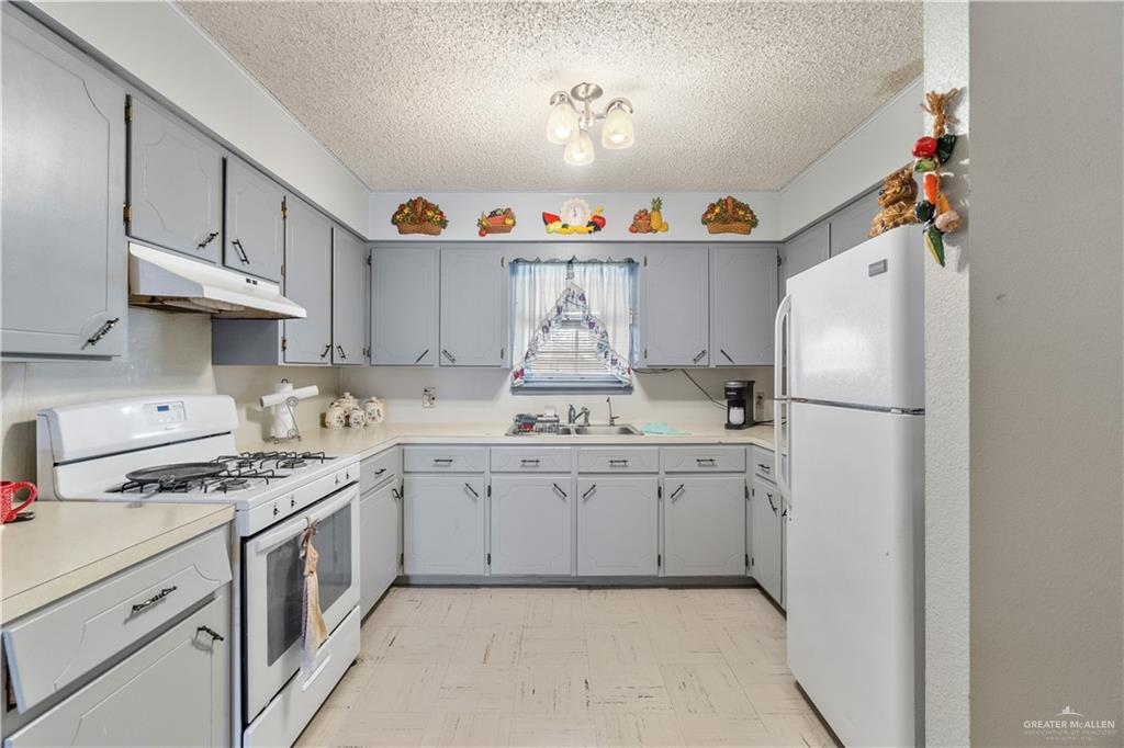 202 North Ester Street Edcouch, TX 78538 - Photo 7 of 13 a kitchen with stainless steel appliances granite countertop a sink stove and refrigerator
