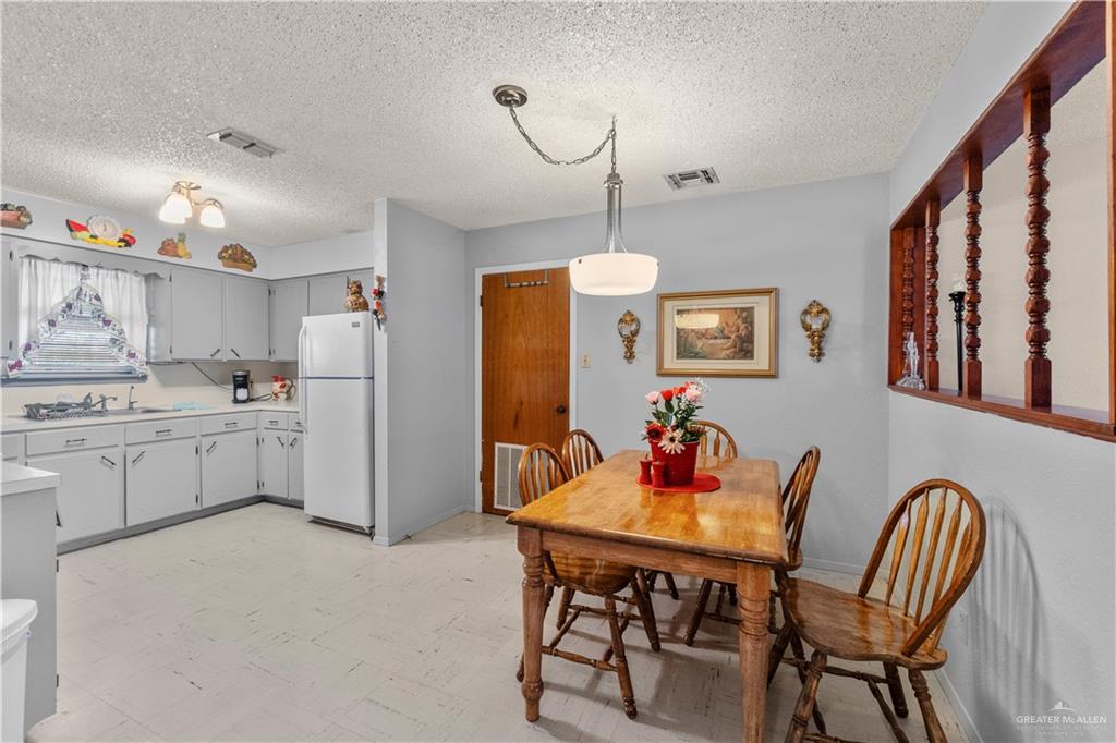 202 North Ester Street Edcouch, TX 78538 - Photo 9 of 13 a kitchen with stainless steel appliances kitchen island granite countertop a dining table chairs and a refrigerator