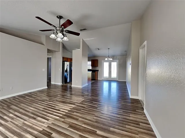 a view of a hallway with wooden floor and a ceiling fan