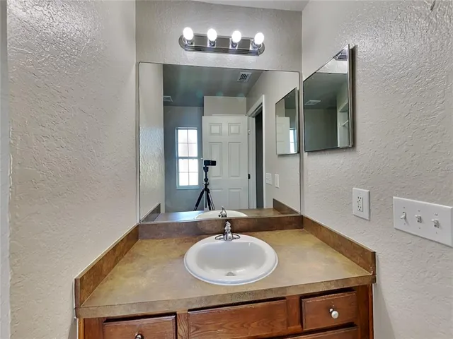 a bathroom with a granite countertop sink and a mirror