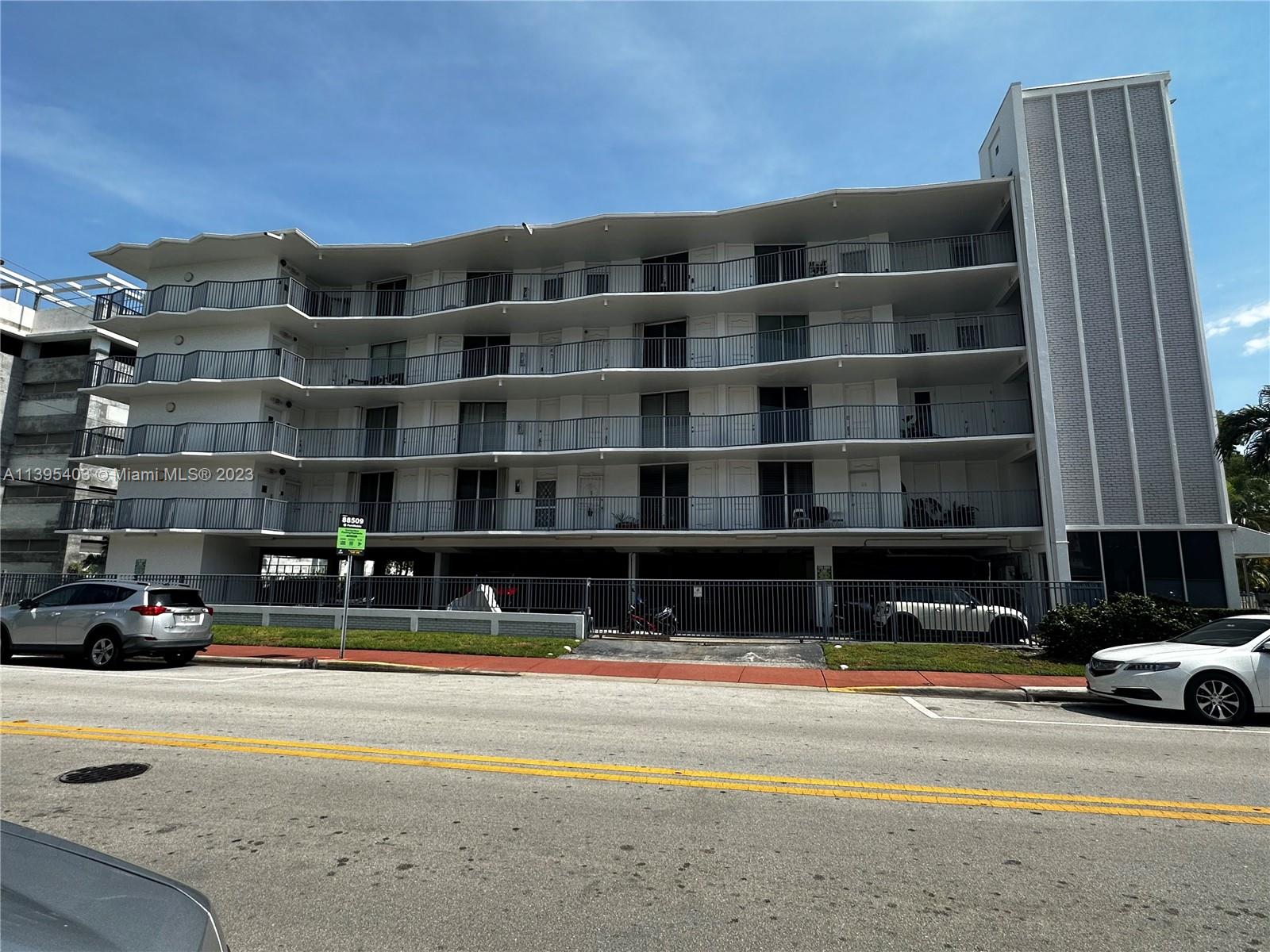 1100 Alton Road, Unit 5B Miami Beach, FL 33139 - Photo 2 of 2 a view of building with cars parked in front of it