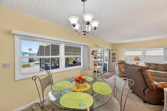 a dining room filled chandelier and kitchen view