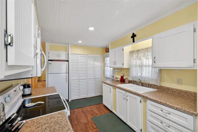 a kitchen with granite countertop a sink stove and cabinets