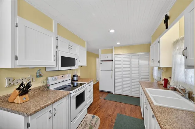 a bathroom with a granite countertop sink and a washing machine