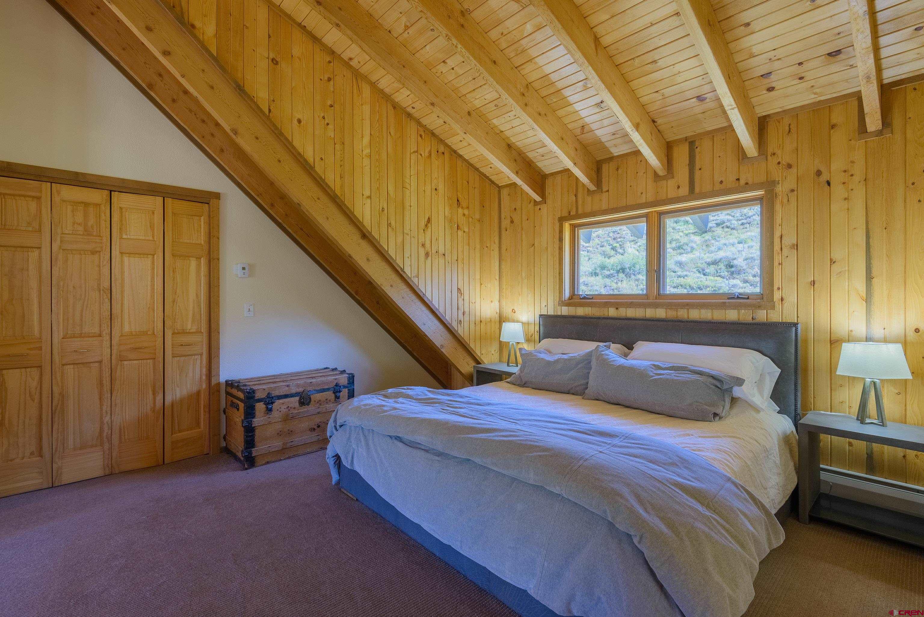 1250 County Road 734 Crested Butte, CO 81224 - Photo 27 of 45 a bedroom with a bed and a chandelier