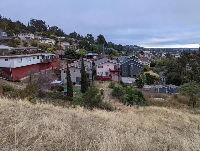 an aerial view of residential house with outdoor space and trees all around