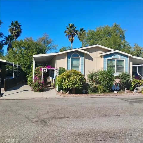 a front view of a house with a yard and potted plants