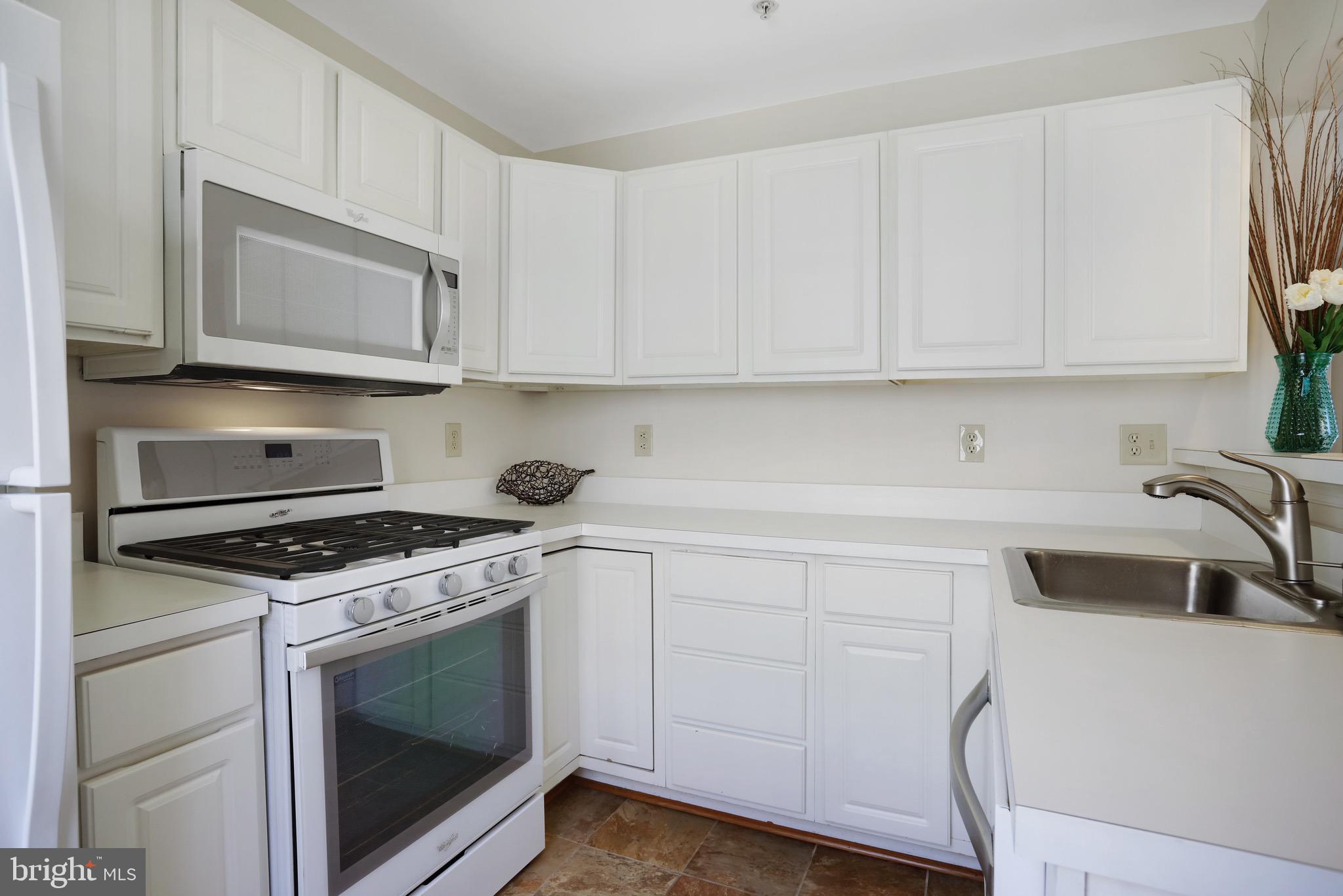 111 Timberbrook Lane, Unit 201 Gaithersburg, MD 20878 - Photo 17 of 38 a kitchen with granite countertop white cabinets and white appliances