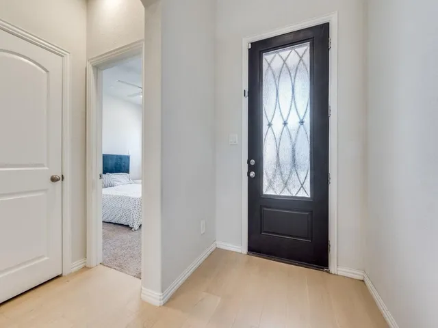 a view of an empty room with a bathroom and mirror