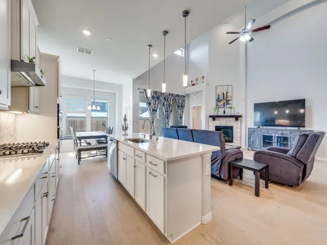 a large kitchen with cabinets chairs and a stove