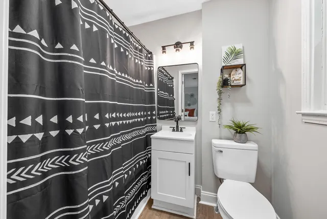 a bathroom with a sink a toilet and a shower curtain