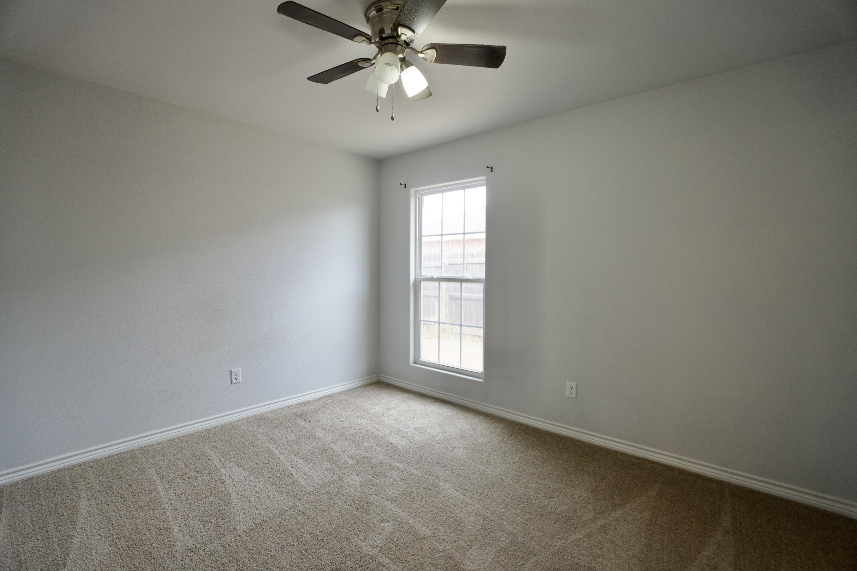 8813 17th Street Lubbock, TX 79416 - Photo 19 of 20 an empty room with windows and fan
