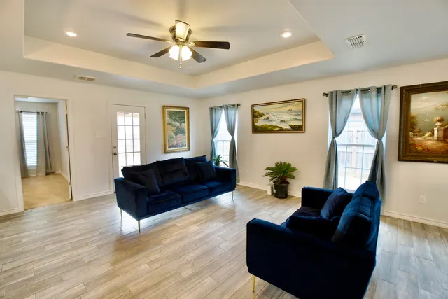 a living room with furniture and wooden floor