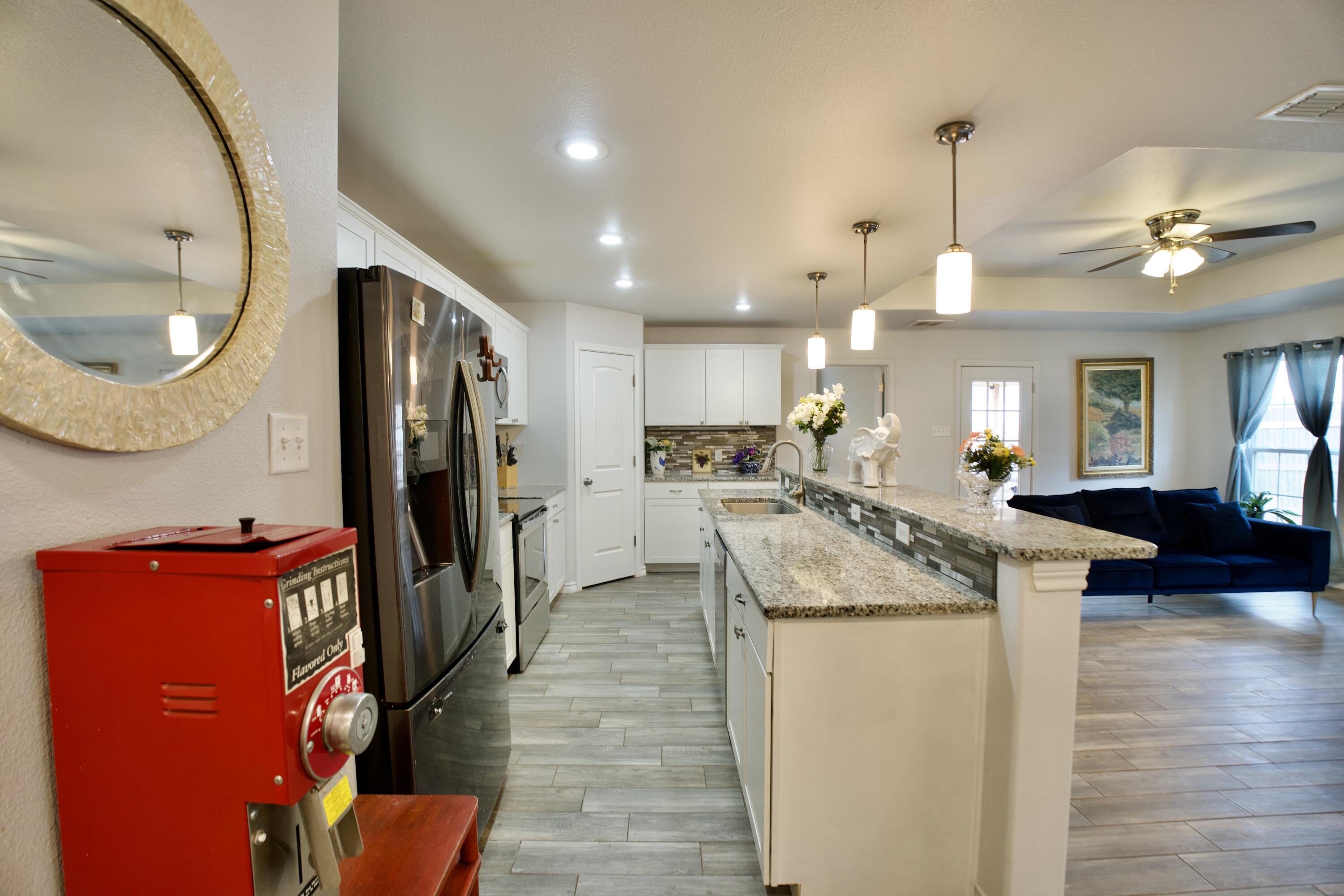 8813 17th Street Lubbock, TX 79416 - Photo 7 of 20 a kitchen with kitchen island a counter top space appliances and a ceiling fan