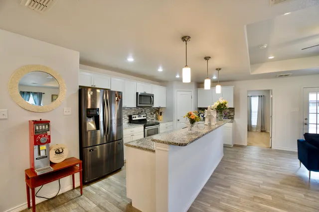 a kitchen with white cabinets and appliances