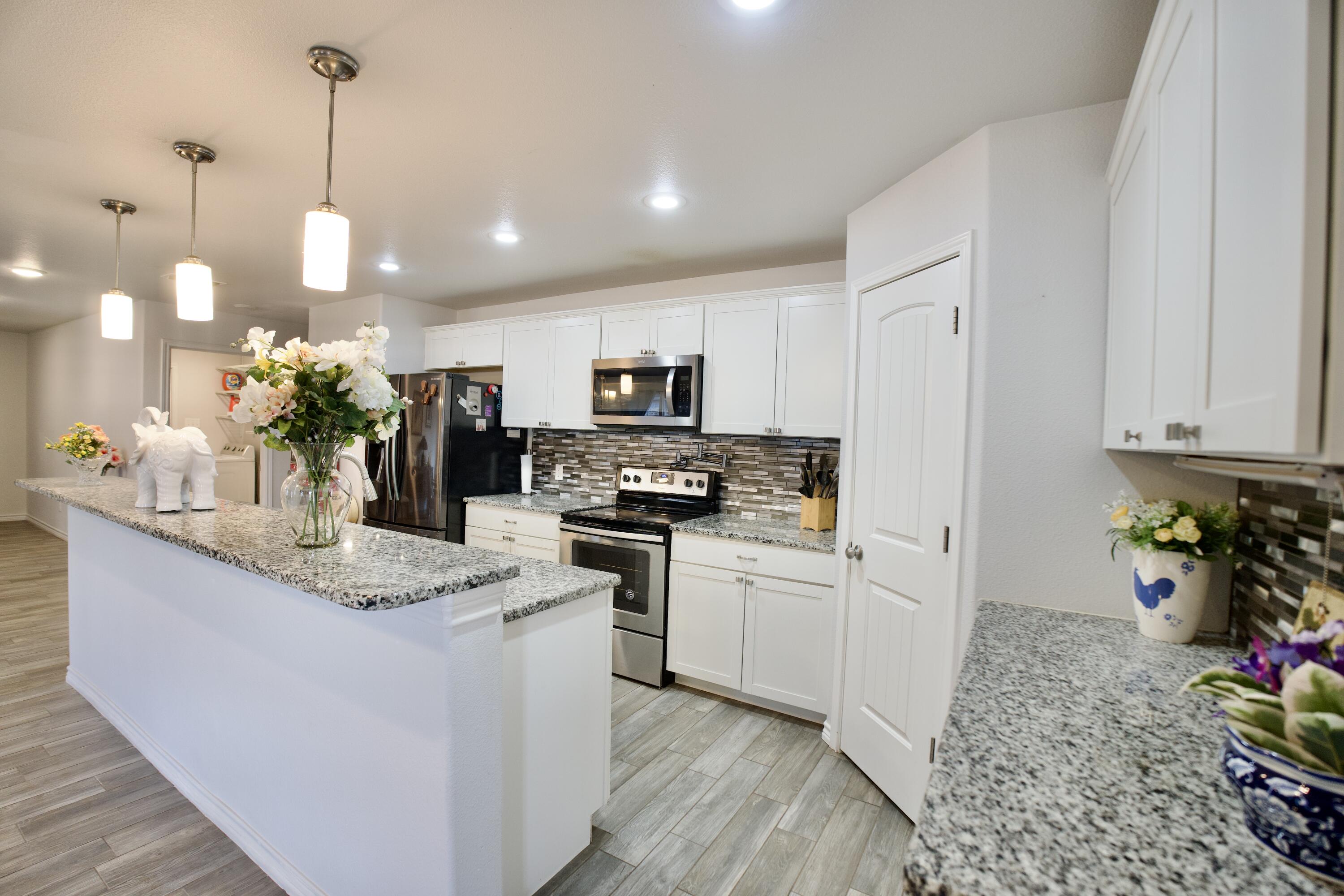 8813 17th Street Lubbock, TX 79416 - Photo 9 of 20 a kitchen with white cabinets and appliances