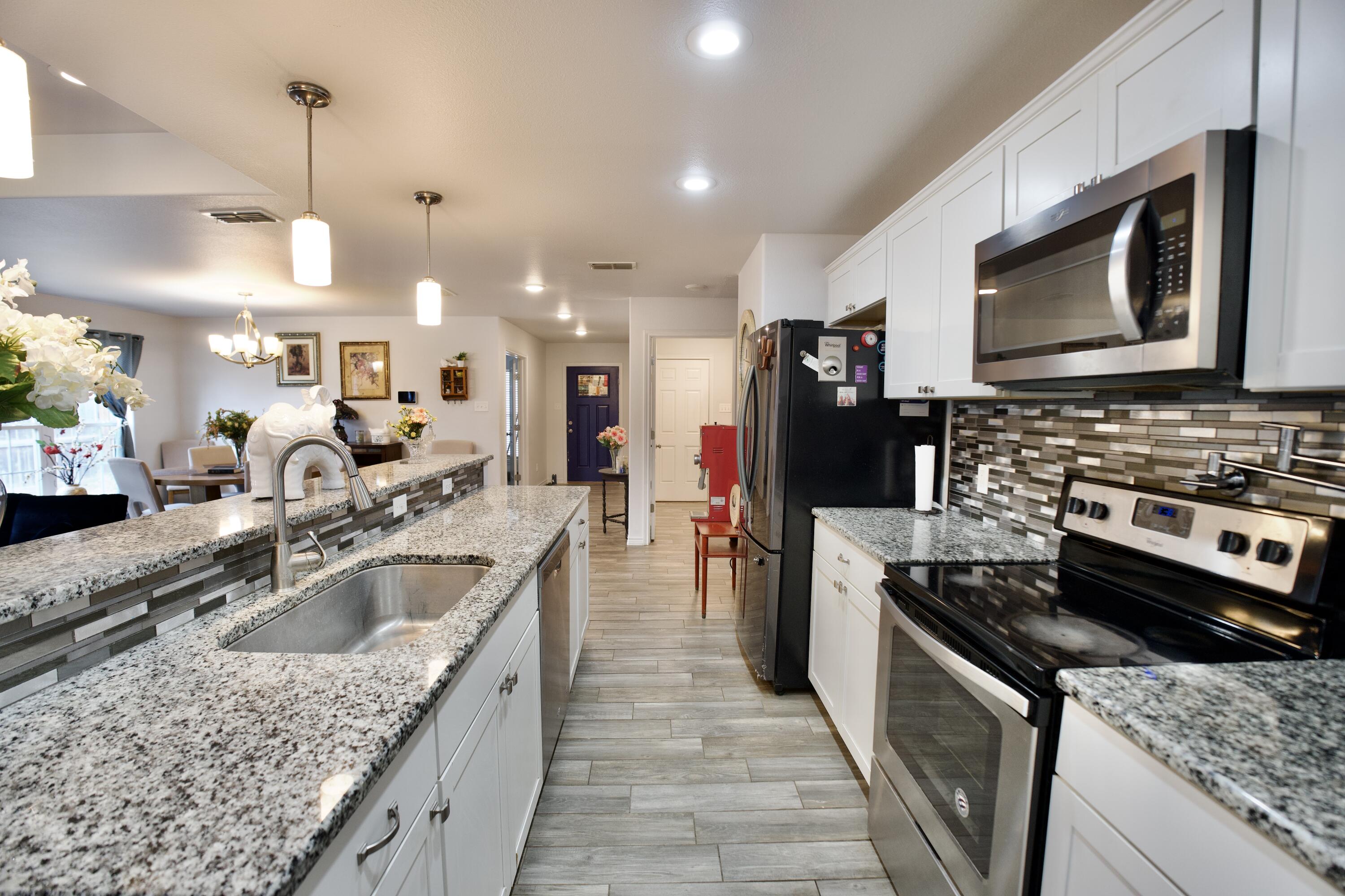 8813 17th Street Lubbock, TX 79416 - Photo 10 of 20 a kitchen with a stove sink and a microwave