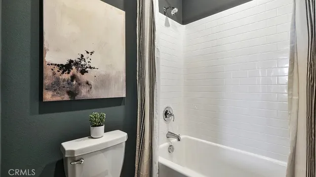 a bath room with a toilet and a tub