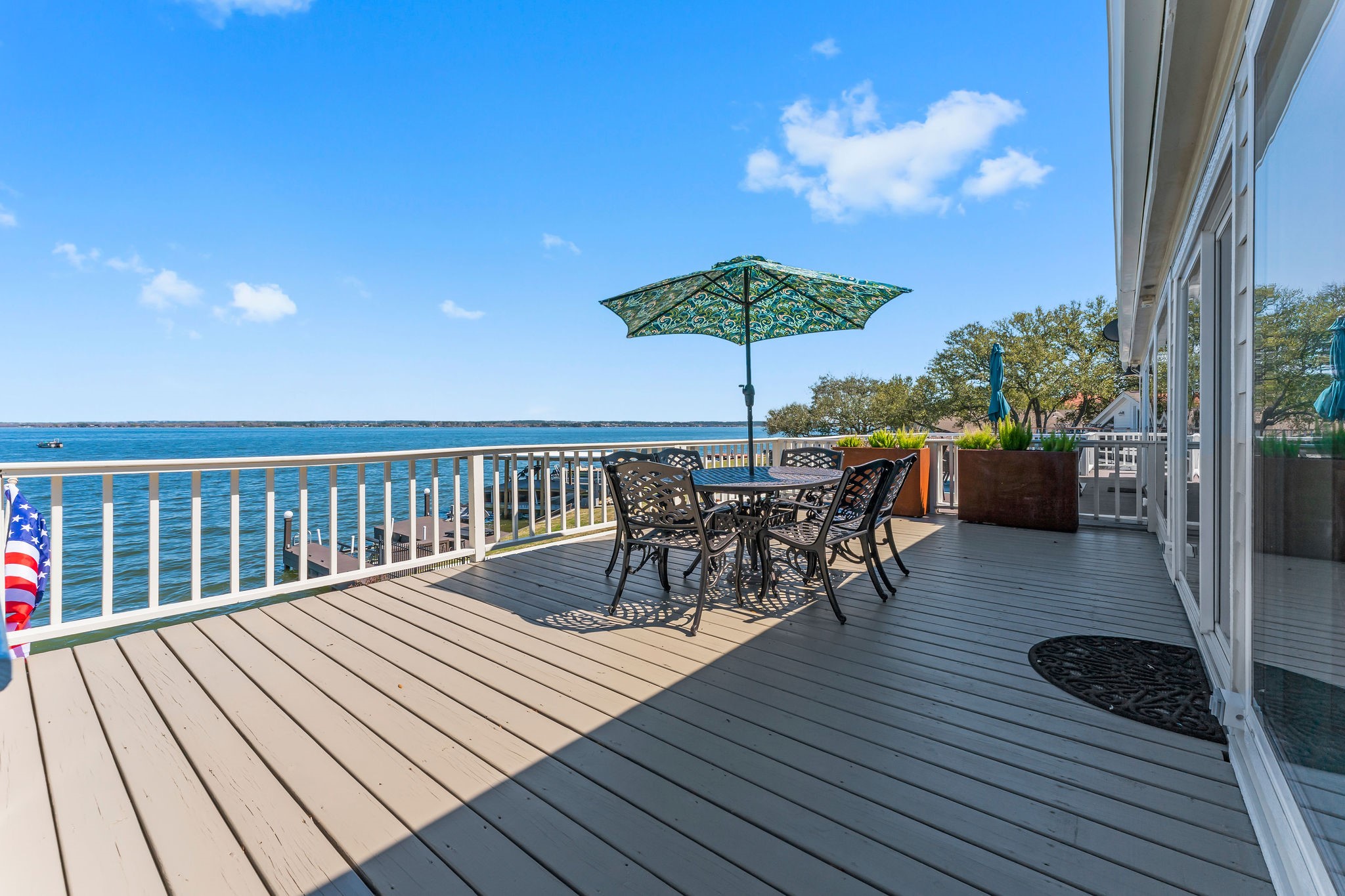 69 Lakeview Village Conroe, TX 77356 - Photo 5 of 50 a view of a roof deck with table and chairs under an umbrella with wooden floor