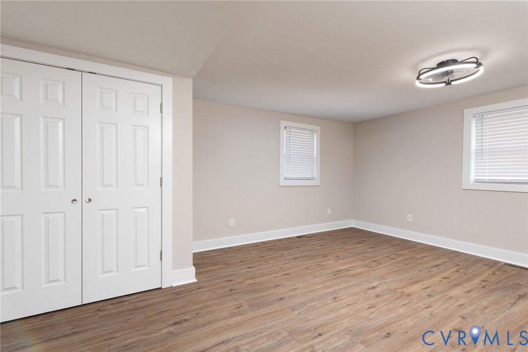 9800 Golf Course Drive Disputanta, VA 23842 - Photo 14 of 19 a view of an empty room with wooden floor and a window