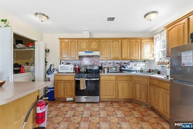 a kitchen with stainless steel appliances granite countertop a sink dishwasher stove top oven and cabinets