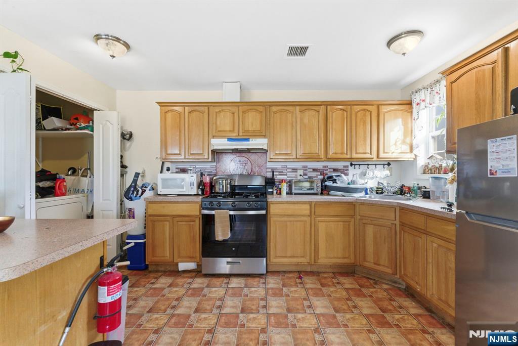29-31 22nd Avenue Paterson, NJ 07513 - Photo 18 of 20 a kitchen with stainless steel appliances granite countertop a sink dishwasher stove top oven and cabinets