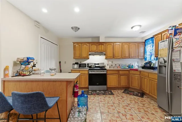 a kitchen with granite countertop a sink stove and refrigerator