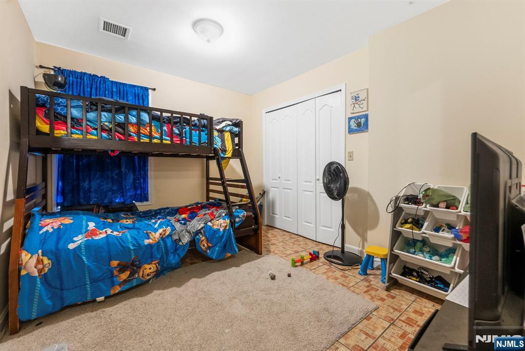 29-31 22nd Avenue Paterson, NJ 07513 - Photo 9 of 20 a bedroom with a bed a dresser and a book shelf