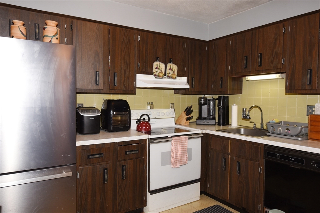 980 Plain Street, Unit 4 Marshfield, MA 02050 - Photo 12 of 26 a kitchen with a sink a stove and cabinets
