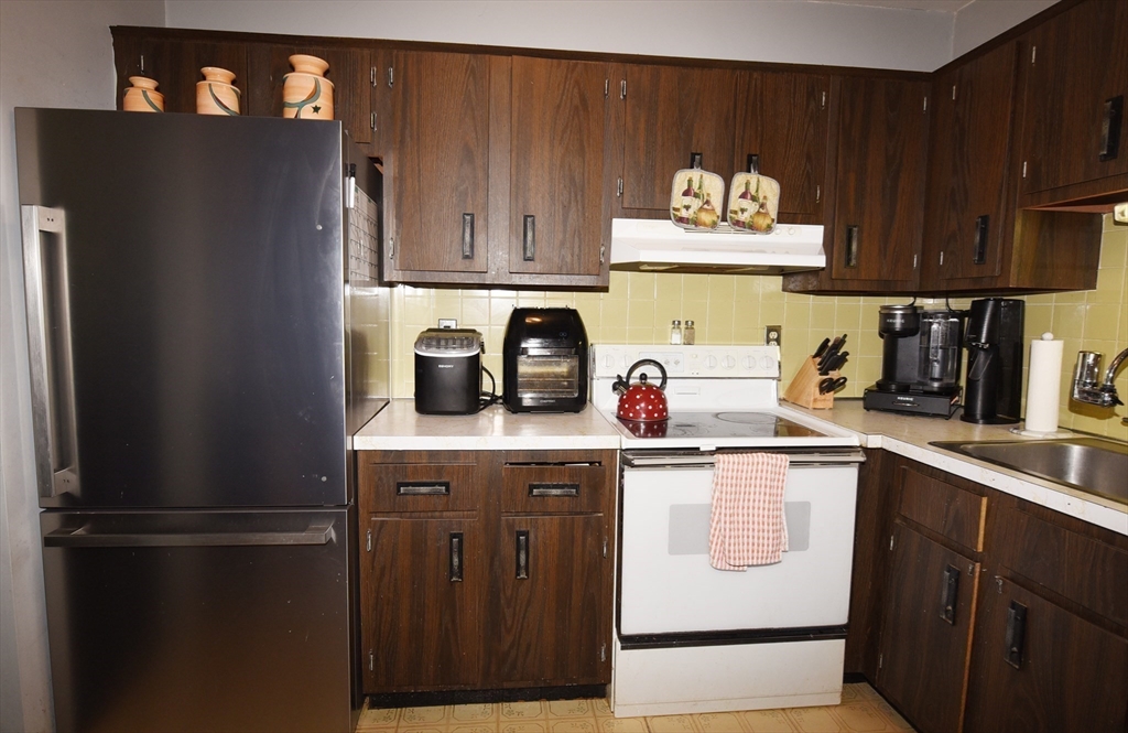 980 Plain Street, Unit 4 Marshfield, MA 02050 - Photo 13 of 26 a kitchen with a refrigerator and cabinets