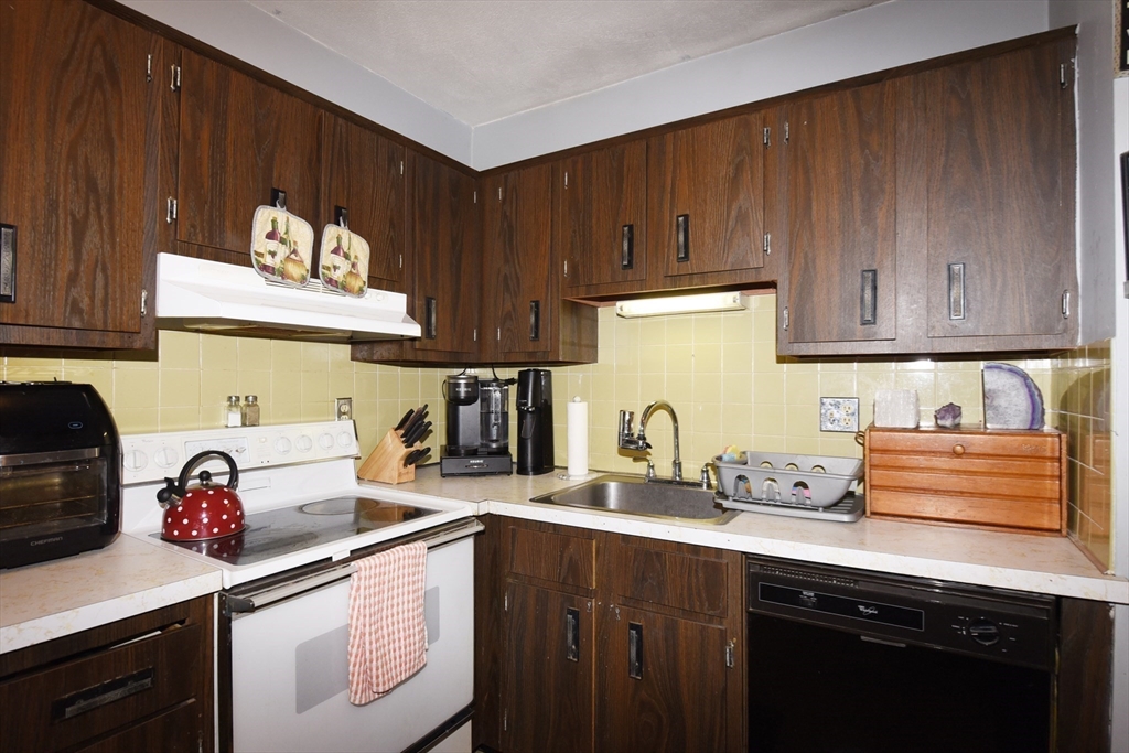 980 Plain Street, Unit 4 Marshfield, MA 02050 - Photo 14 of 26 a kitchen with stainless steel appliances granite countertop a sink stove and cabinets